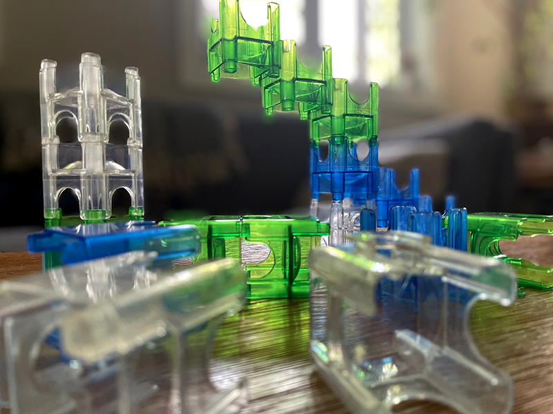 Gros plan sur un jeu de billes avec des pièces de couleur verte, bleue et transparente sur une table en bois.