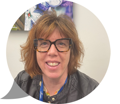 Wendy_Kemp Une femme portant des lunettes avec une monture en corne sourit à l'appareil photo depuis son bureau. Photo : Dre Wendy Kemp